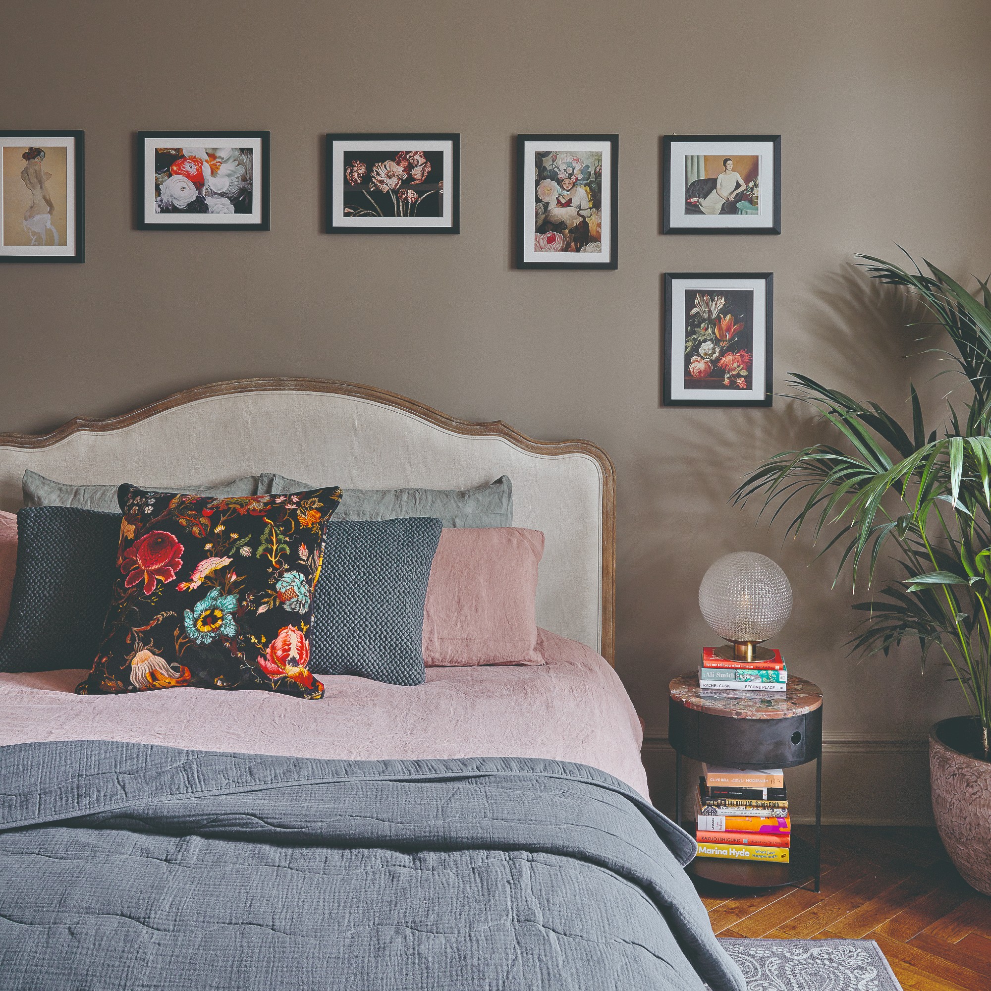 Gallery wall above a bed with coordinated frames